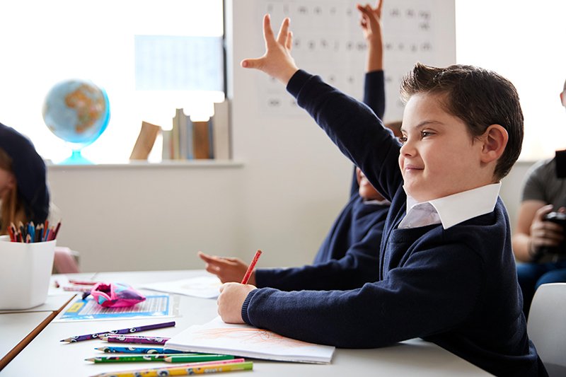 Kid raising hand in class to ask question